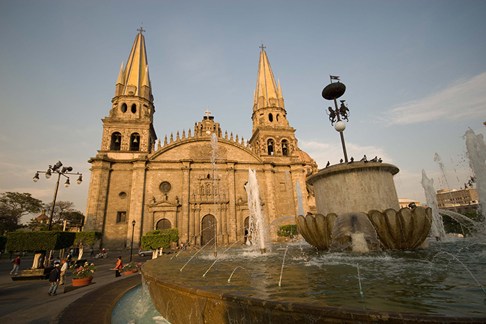 Fotografía donde se aprwecia en primer plano una fuente y al fondo se distingue la fachada completa de la catedral de Guadalajara.